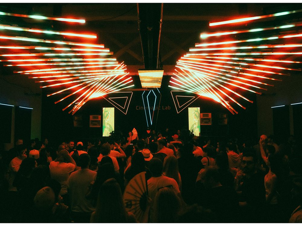 Winged LED light installation spanning the ceiling over a full room